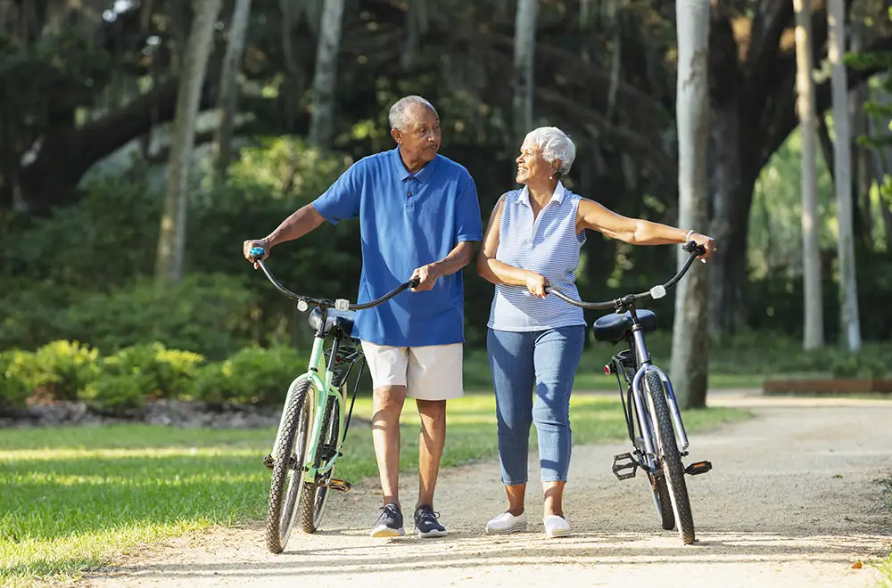 couple walking together with bicycles